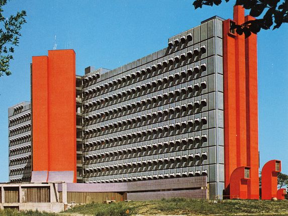 . Bolnišnica dr. Franca Derganca, edina splošna bolnišnica in urgentni center na slovenskem Goriškem, ki s svojo markantno obliko in barvno fasado sodi med najbolj prepoznavne stavbe v regiji. Fotografija iz osemdesetih let. &copy;Razglednico hrani Pokrajinski arhiv v Novi Gorici - PANG 667 Zbirke razglednic krajev Šempeter pri Gorici, št. 2035